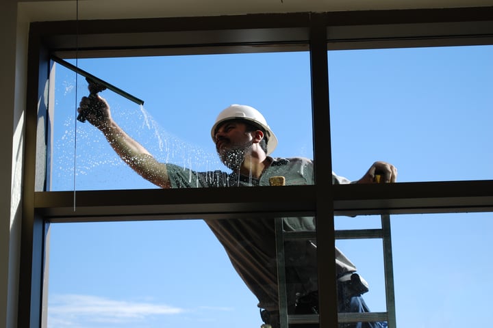 A professional property services team cleaning windows for a high-rise building