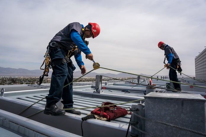 A team of professional window cleaners rope climbing a tall building to clean windows