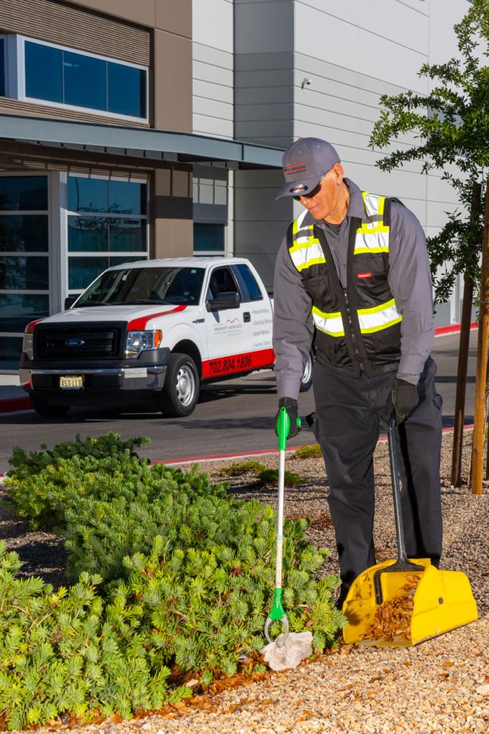 Red Rock Property Services porter picking up trash from a property 
